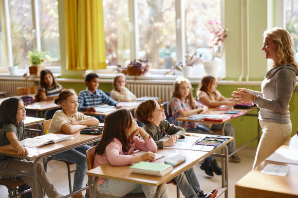istock Happy students enjoying in lecture by their elementary teacher. 2205474157