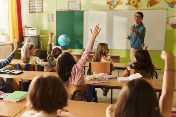 istock Rear view of students know the teacher's question at elementary school. 2205474367