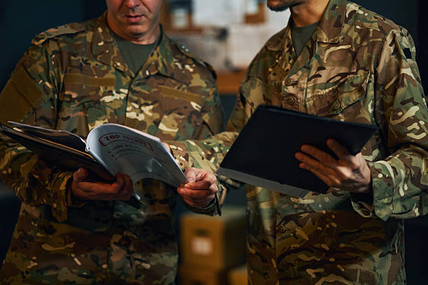 istock Discussing Military Strategies in Camouflage Uniforms 2205475292