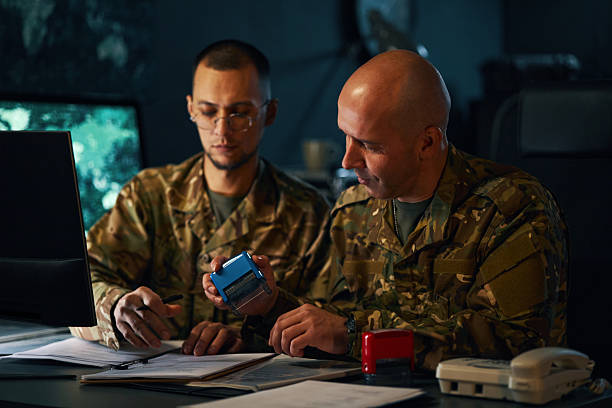 istock Military Personnel Reviewing Documents in Office Setting 2205475682