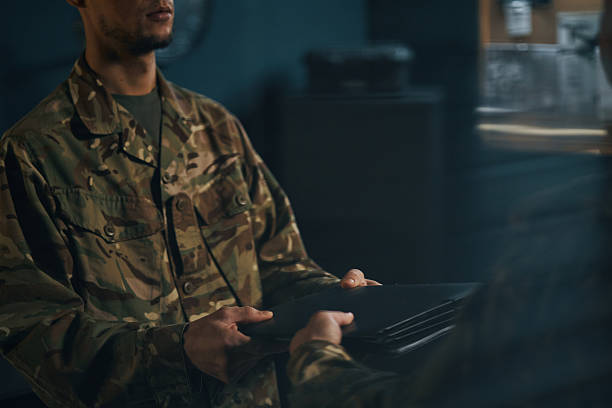 istock Exchanging Documents in Military Uniform in Dimly Lit Room 2205475754