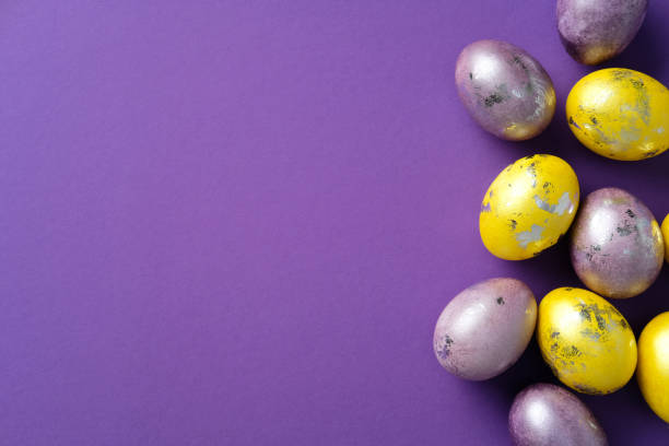 istock Vibrant Easter eggs with metallic accents on a purple background. Flat lay, top view, minimal style. 2205477709