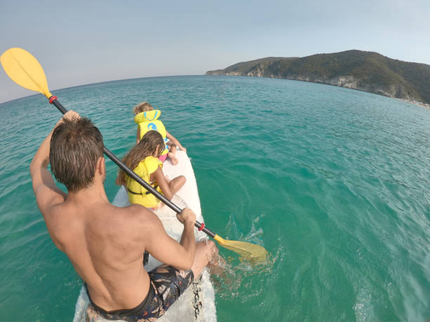 istock Attractive family paddling on a surfboard during a sunset 2205481269