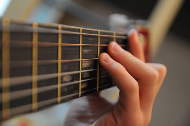 Child learning guitar chords stock photo