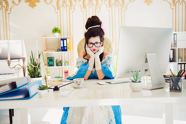 istock Elegant young woman in historical costume working in a modern office setting, representing a blend of historical and contemporary themes. 2205485075