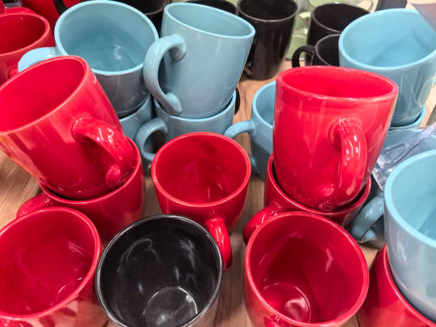 istock Colorful ceramic mugs arranged on a wooden table at a bustling market 2205486330