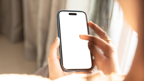 istock Close up of Woman hand holding using touch mobile phone white screen mockup. Back view 2205487640