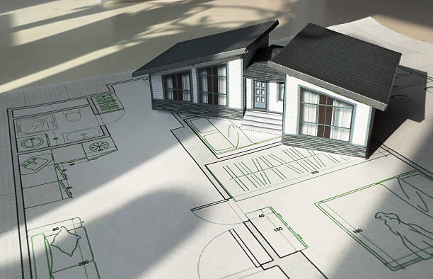 istock Construction blueprints concept. Residential building drawings and architectural house model on an office desk, copy space, template. Architect engineer workplace 2205489104