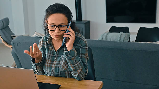 istock Focused Woman in Home Office on a Phone Call Working Remotely 2205489303