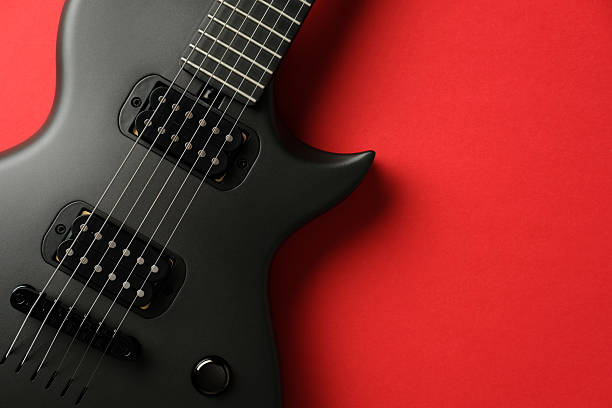 istock Black Electric guitar on red background, musical instrument concept 2205490535