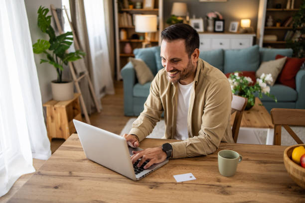 istock Mid adult man working from home and using laptop computer 2205493902