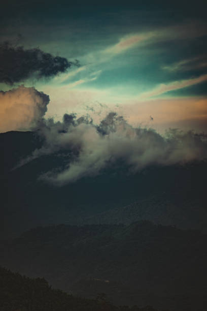 vintage style photo of a lonely cloud within a shadowy mountain range