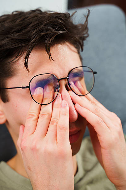 istock Eye tiredness from working remotely at home. Tired IT specialist with headache in front of laptop. 2205497431