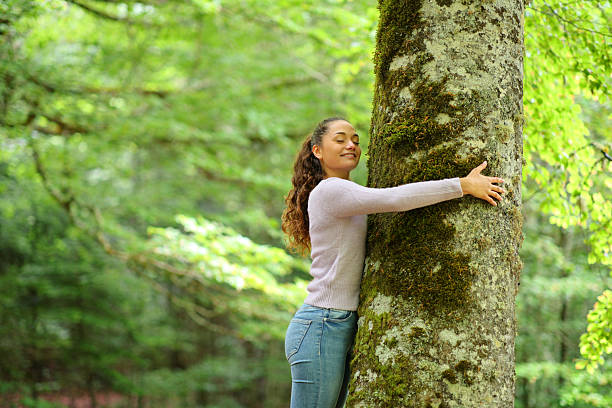 istock Casual woman and nature lover hugging a tree in a forest 2205498765