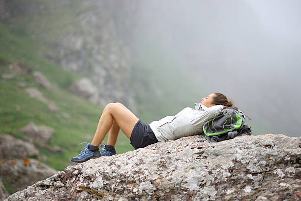 istock Hiker resting and relaxing lying on a rock in the mountain 2205499108