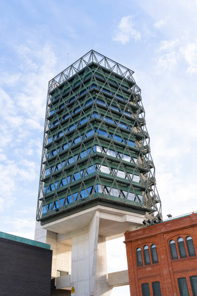 istock Modern green building with exposed metal truss frame in urban setting 2205500444
