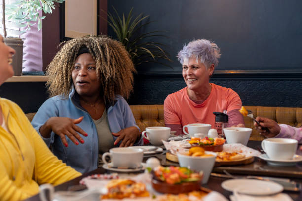 istock Women Sharing Pizza And Stories During Relaxed Gathering 2205502275