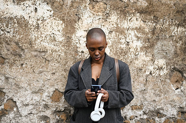 istock Young african woman using smartphone against old wall 2205507849