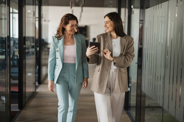 istock Two Women Laughing Together in Modern Office 2205508767