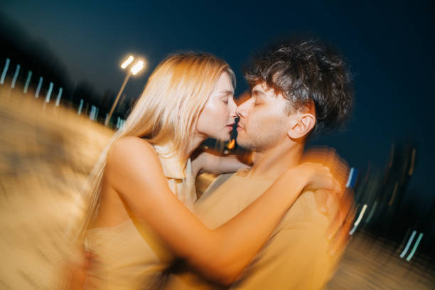 istock Romantic couple sharing a passionate moment under city night lights 2205509475