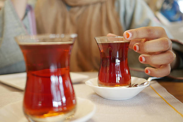 istock woman drinking Traditional turkish tea on white table . 2205510071