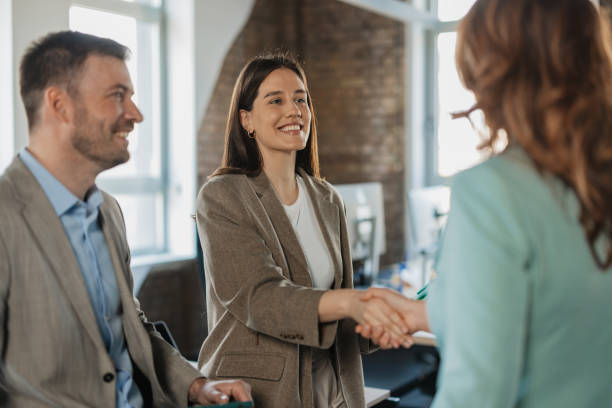 Smiling colleagues shaking hands in a bright office
