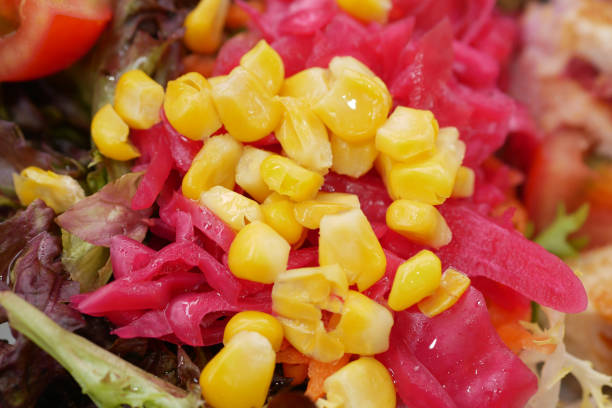 A vibrant salad with pickled pink vegetables and sweet corn, visually appealing and tasty