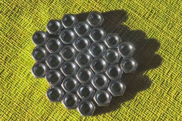 Macro photo of plastic pipes and metal nut gears. No people are seen in frame. Shot in studio with a full frame mirrorless camera.