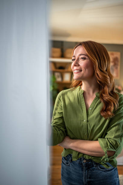 Smiling woman looking out the window at home