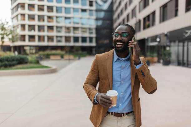 istock Businessman talking on phone with coffee outdoors 2205517687