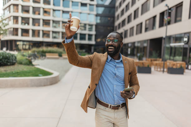 istock Man joyfully raising coffee in urban setting 2205517815