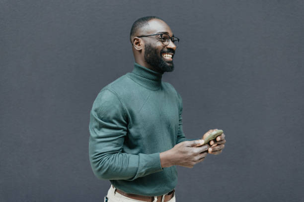 istock Smiling man holding phone and showing excitement 2205517854