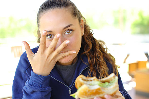 istock Woman eating a finger-licking good hamburger 2205518774