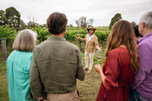 istock Host and wine tasters in Hunter Valley vineyard, springtime 2205520638