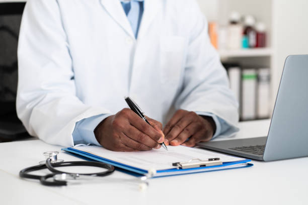 istock Doctor writing on document on desk at hospital 2205522055