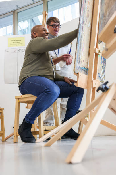 istock Smiling disabled men painting in workshop 2205524405