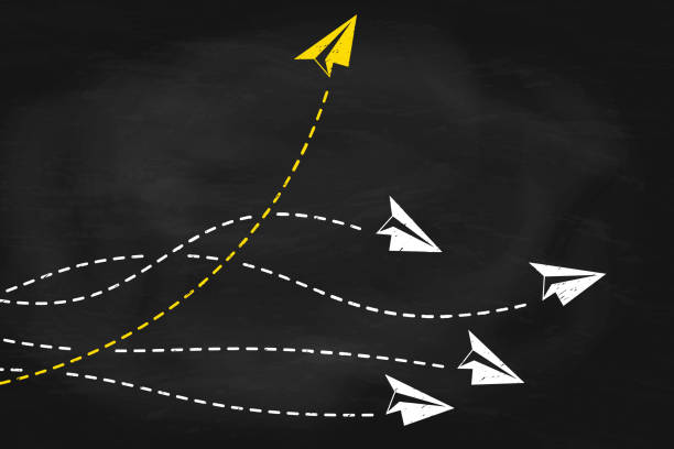 istock Individual and yellow paper plane flies to the side on black chalkboard 2205526535