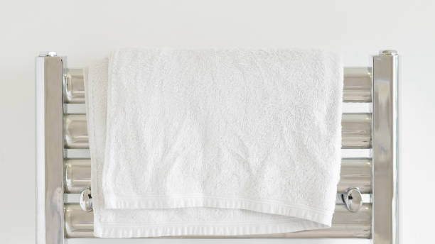 istock Fresh white towel on a modern heater, elegant home decor, soft and cozy. 2205526714