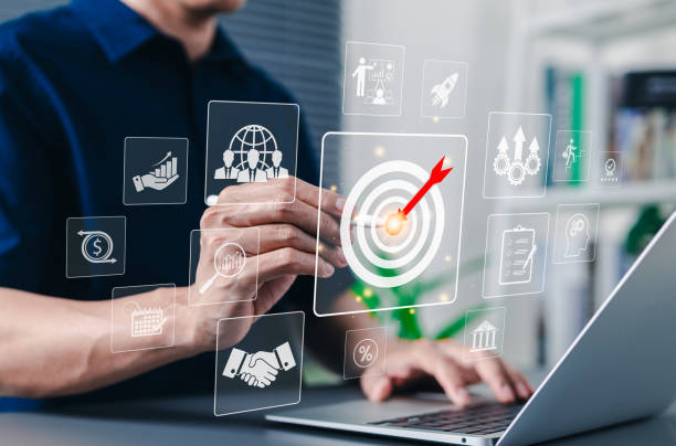 istock Business goal and target achievement concept. Businessman using laptop interacting with digital interface bullseye target with an arrow, goal setting, strategy, and success in business planning. 2205527424