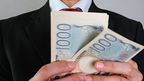 istock Businessman holding Japanese banknotes 2205527915