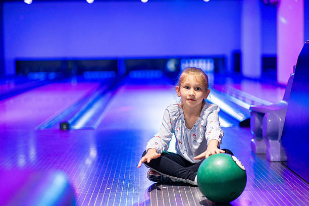 istock happy young girl having fun cheering while playing bowling game bowling alley 2205528848