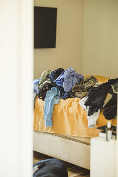 istock Mess of clothes on bed at home 2205528852