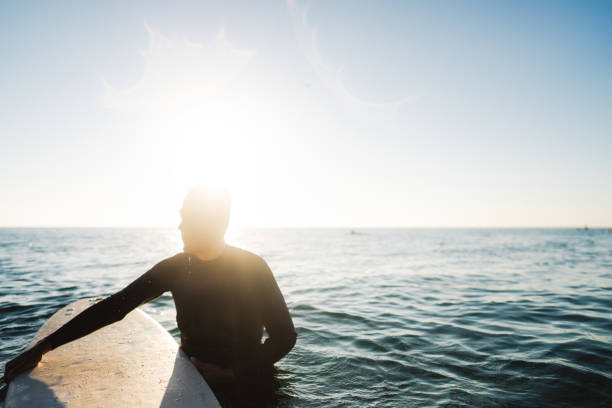 Portrait of a senior man, holding his surfboard