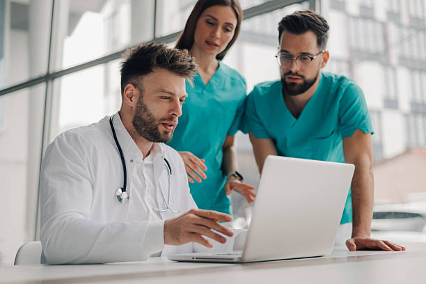 istock Medical team analyzing patient data on laptop in hospital 2205531873
