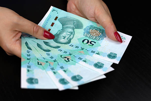 istock Chinese yuan banknotes in female hands 2205532740