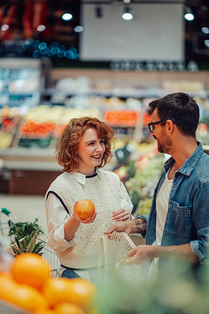 istock Young couple choosing oranges in the supermarket 2205533145