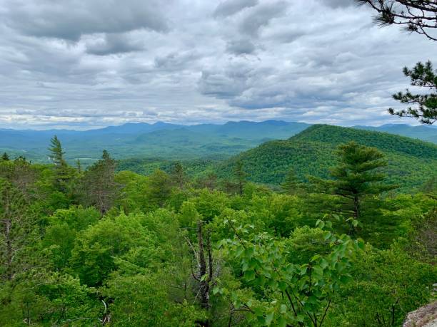 istock Scenic view of lush green mountains under a cloudy sky. 2205533372