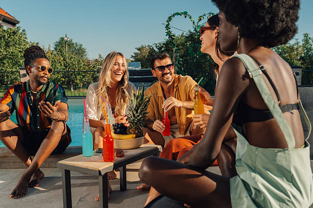 istock Friends enjoying drinks and conversation by the poolside 2205533559