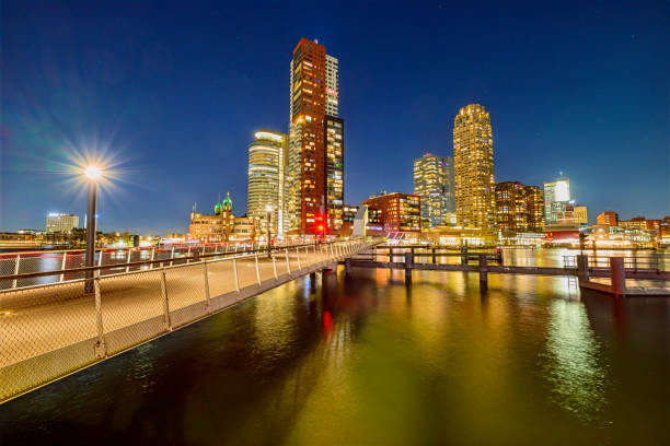 Rotterdam evening view on the Kop van Zuid at the Rijnhaven. Various buildings stand tall in the night including the old Hotel New York, the World Port Center, Montevideo and New Orleans buildings. The name \