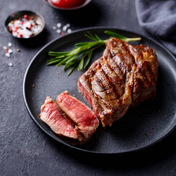 istock Beef Steak medium rare on a black plate. Dark grey background. Close up. 2205533694